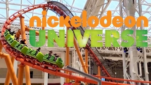 Image shows the text "Nickelodeon Universe" in front of an indoor winding rollercoaster