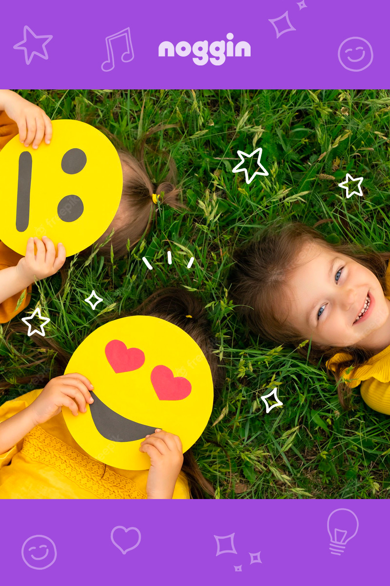 kids laying in grass with smiley face posters